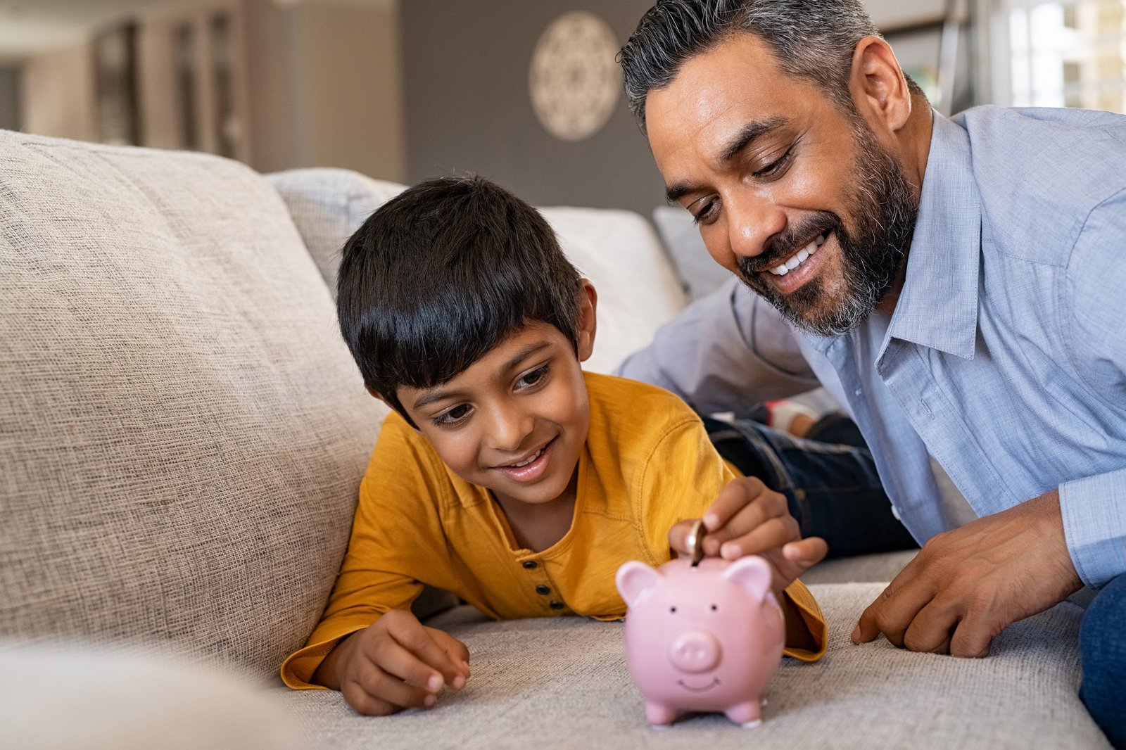 Father Teaching Son Fiscal Responsibility Using Piggy Bank